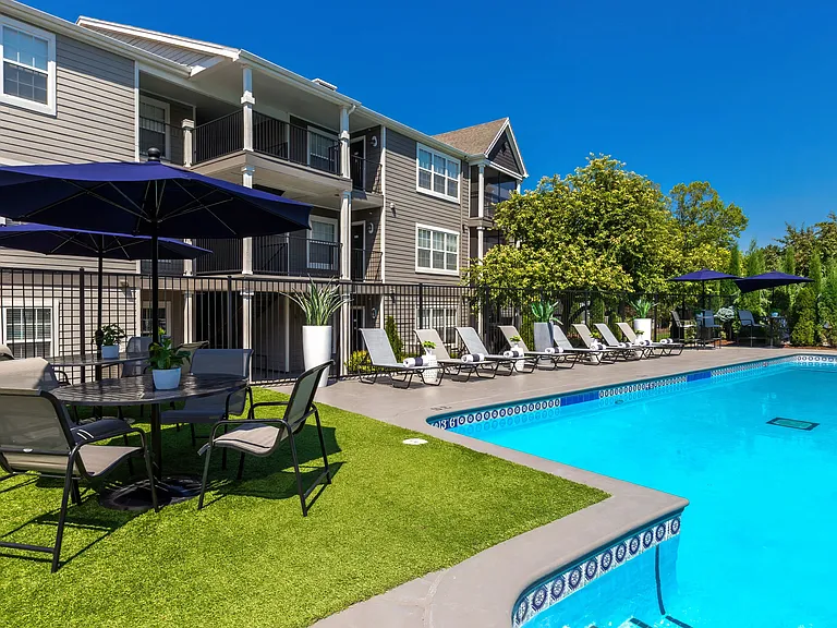 Savor shade and relaxation under stylish umbrellas at poolside tables.