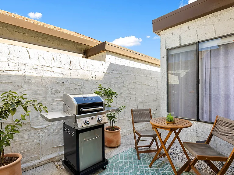 Back patio with gas BBQ, bistro set and a couple young Meyer Lemon trees. This patio leads to a rear exit, perfect for a quick walk to the grocery store.