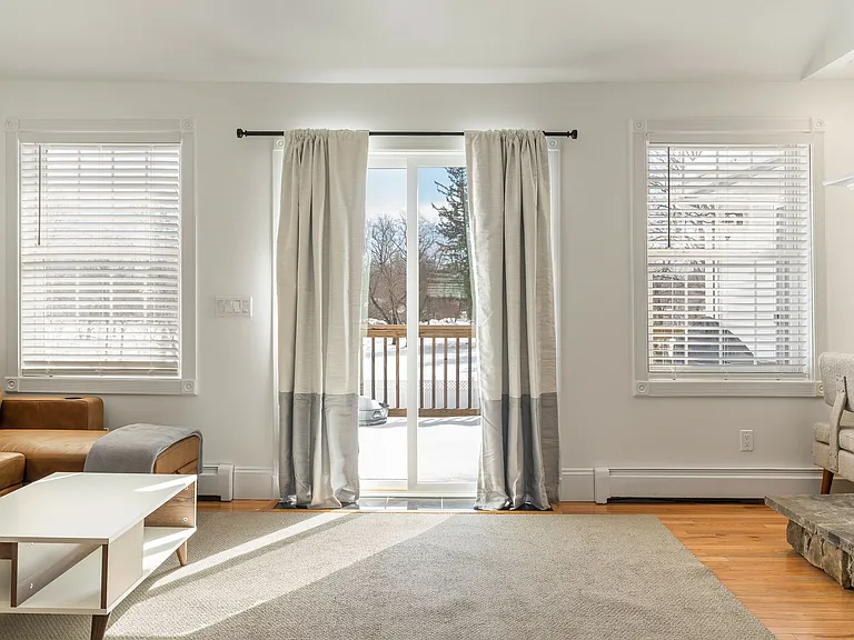 Living Area, Natural Light, Sliding Glass Door, Hardwood Floors, Fireplace, Large Windows, Area Rug.