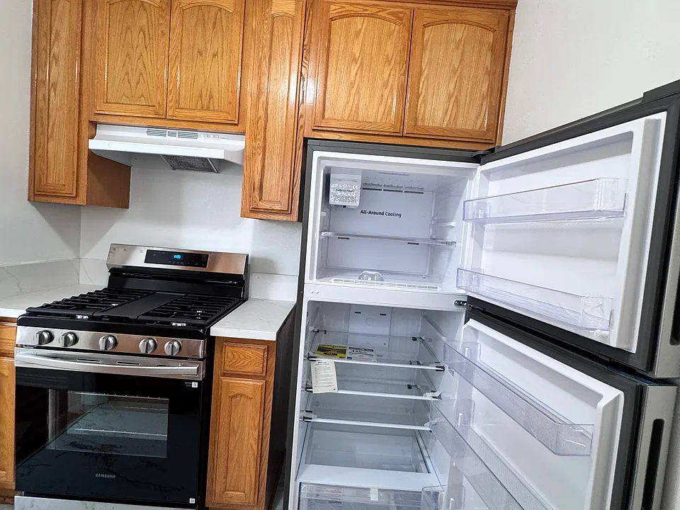 Bright, clean and freshly painted kitchen includes new refrigerator and new stove, new counter tops, and ample cabinet space.