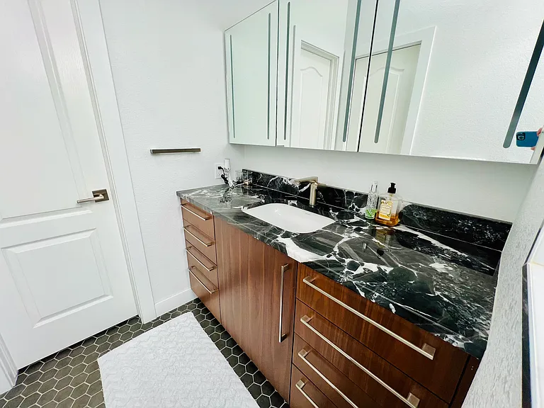 Marble and Walnut finished with high-end medicine cabinet mirror that allows for even more storage.

Walk in Closet access from the bathroom.
