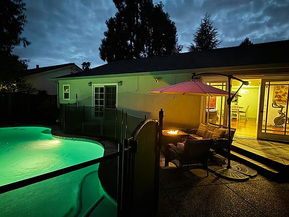 Backyard and Living Room At Night with Pool and Interior lighting