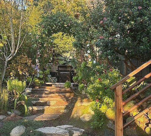 Stairs to front door on the right. Looking towards the back yard with flowering arbor.