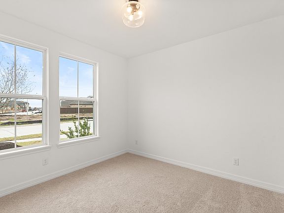 The third bedroom features plush carpet, fresh paint, closet, and a large window that lets in plenty