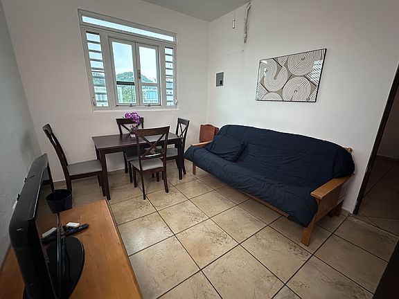 Comfortable living room area with dining table for 4, a futon that converts to a full bed, and TV with Roku.