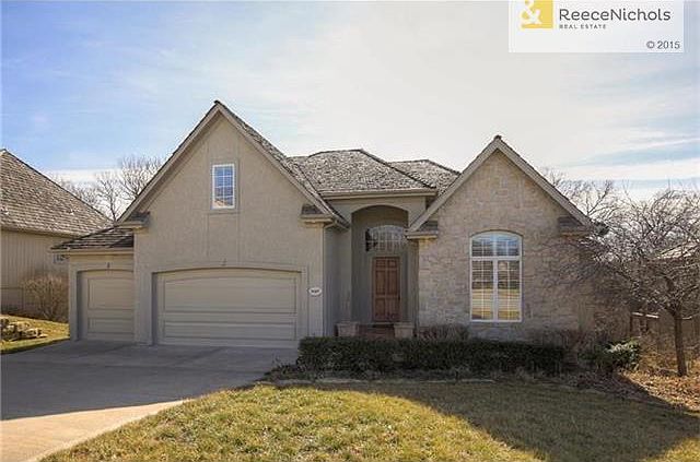 EXTERIOR ALL STUCCO AND STONE SITTING ON A TREED WALK OUT LOT