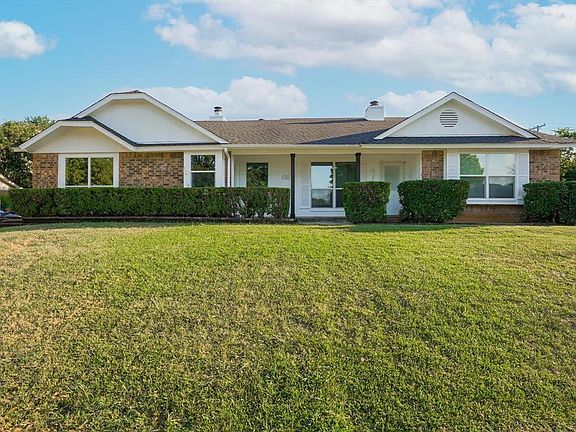Ranch-style home with brick siding, a front lawn, and a chimney
