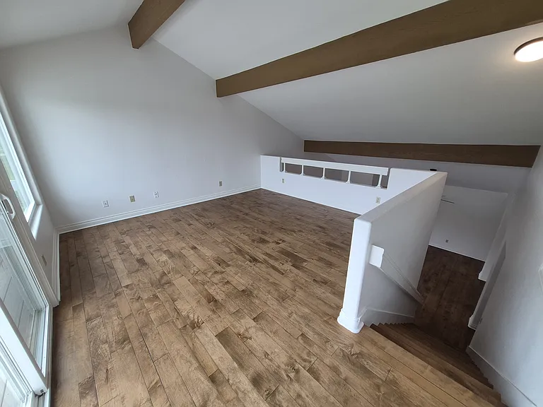 Upstairs loft has beautiful refinished wood floors.
