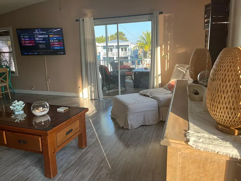 Living room view to sliding glass door that connects to upstairs deck. Nice reading/ napping spot with a view to the outside.