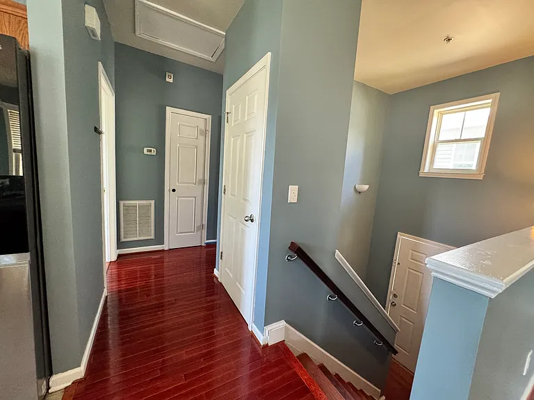 Head downstairs where the rich red hardwood floors continue, guided by classic wooden handrails all the way down.