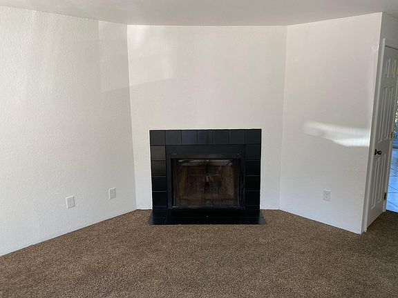 Big living room with lots of natural light and wood burning fireplace
