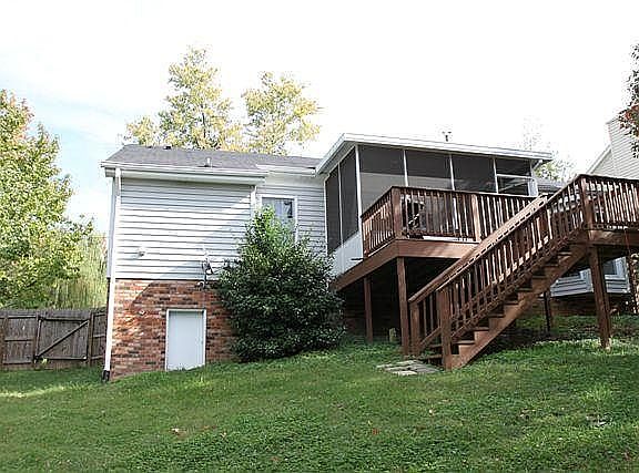 Back of house from the fenced-in backyard showing the screened in porch