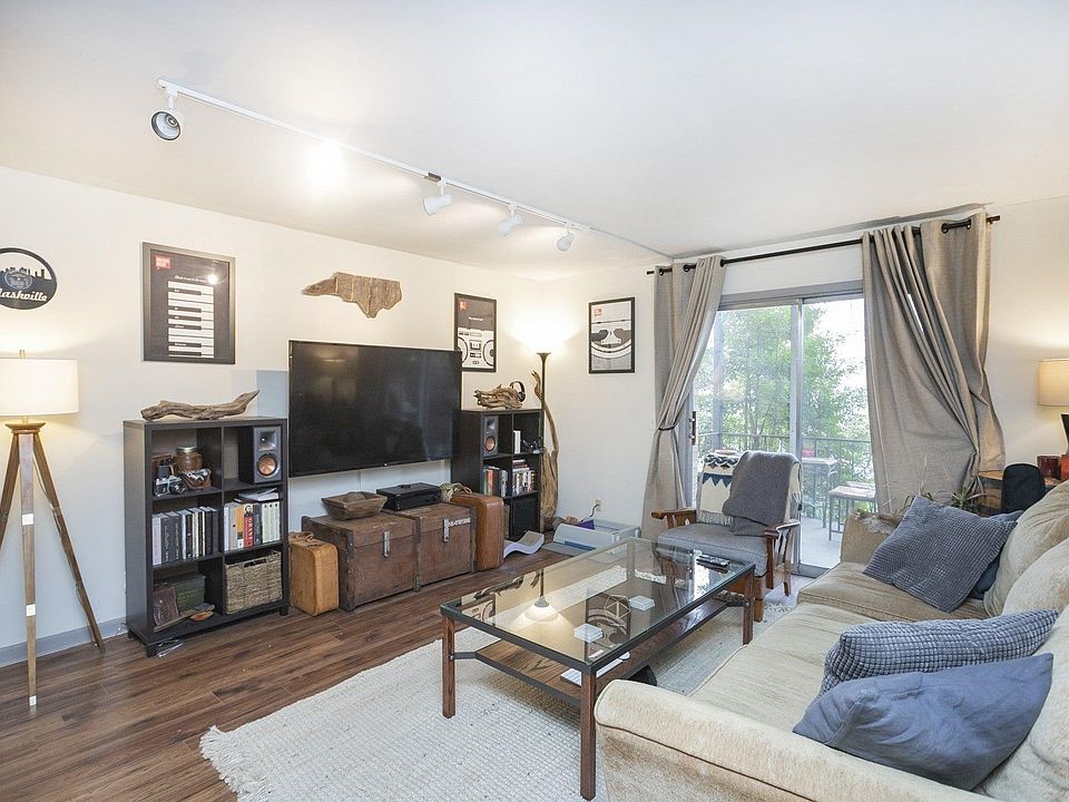 spacious living room with porch. Behind camera is an open dinette area that connects to the kitchen (this tenant used that spec for a desk)
