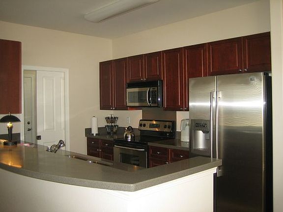 The kitchen with hazelnut custom cabinets, corian countertop, stainless appl