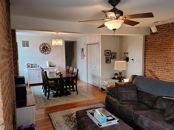 Looking west from William Street, towards kitchen and deck entrance, half bath with laundry, and upstairs staircase. .
