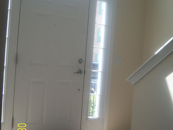 Sun-drenched front door / foyer staircase (leads up into living room area)