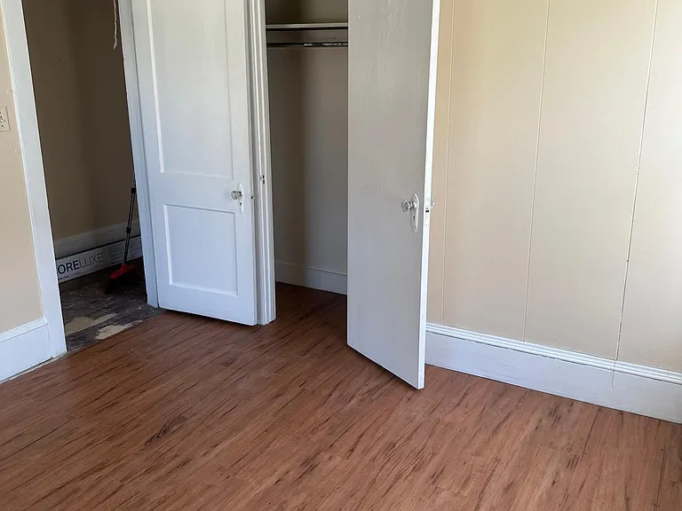 Front bedroom looking at closet and door leading to living room.