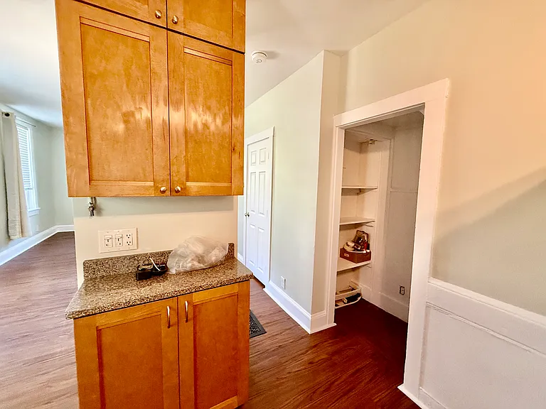 View of island cabinet and counter and pantry