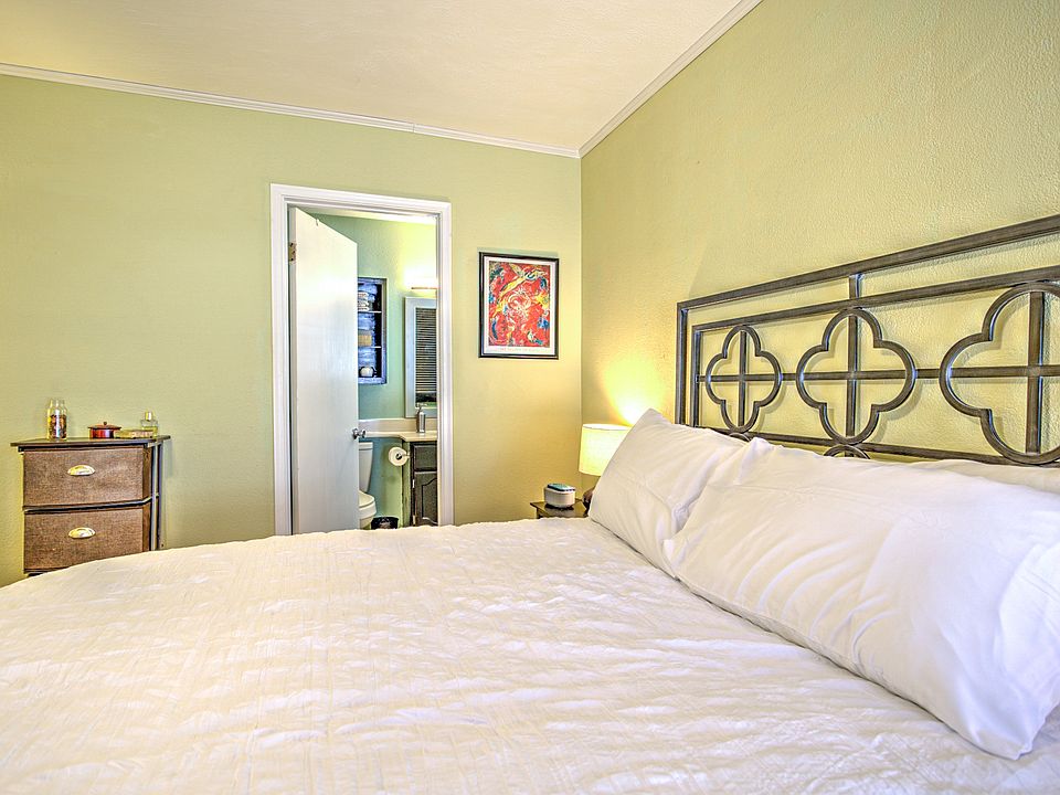 Bedroom with large closet, dresser, its own bathroom and television.