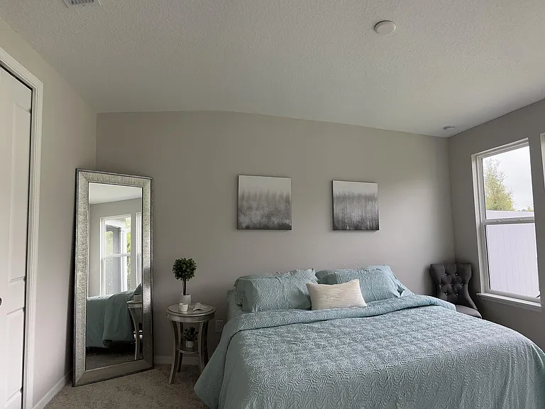 King size bedroom with plenty of windows for natural light and deluxe primary bathroom