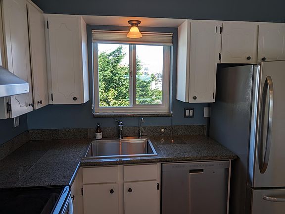Window above sink looks out into trees