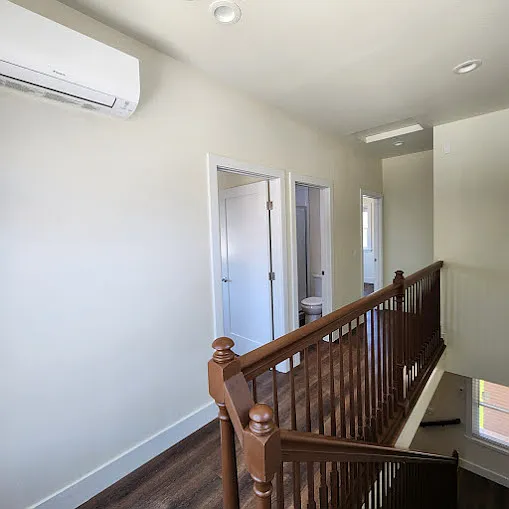 Walkway with wall mounted split-air conditioner leading to 2 bed rooms & a common bath room & washer & dryer.