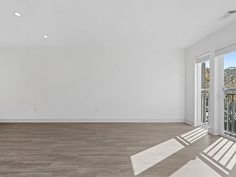 Expansive Living Room with Oversized Windows and Plank Flooring