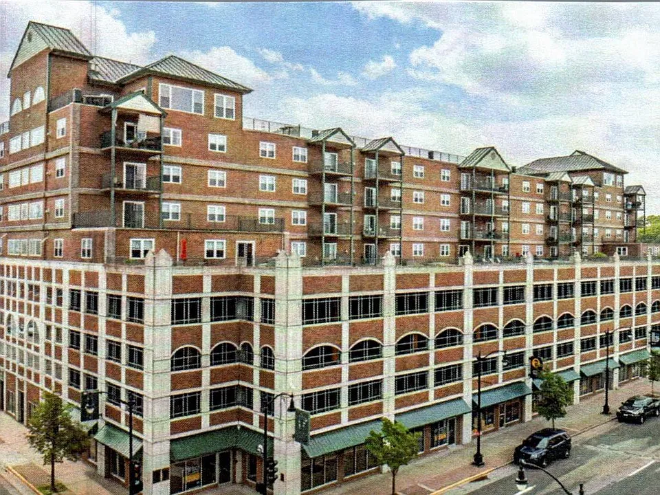 Elegant urban apartment complex showcasing modern architecture with multiple floors, balconies, and ground-level retail spaces.