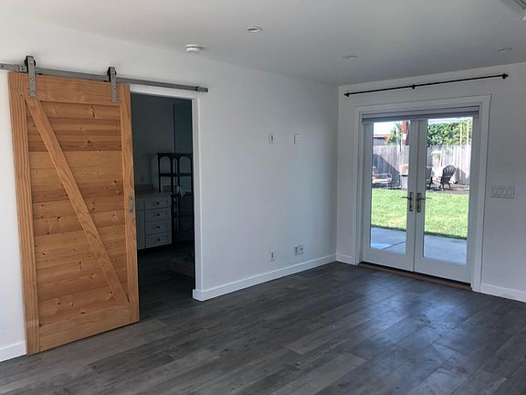 Inside bedroom with second set of French doors to back yard.