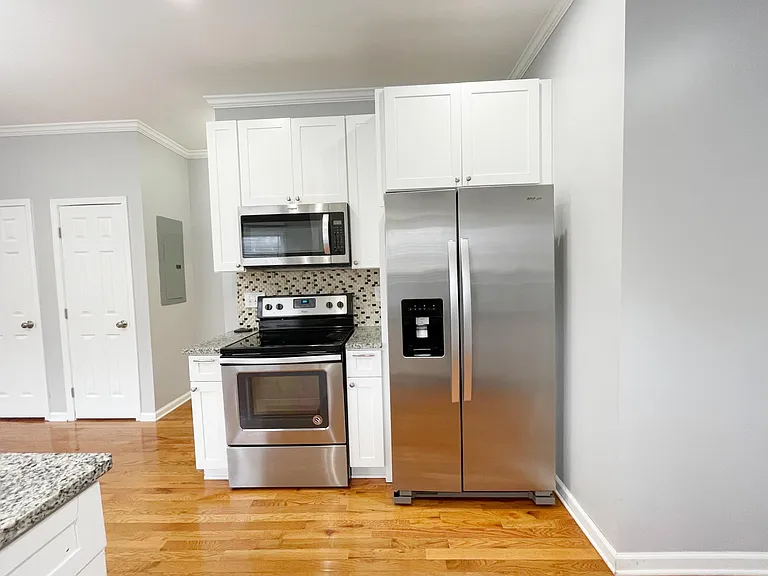Kitchen with stainless steel appliances: electric stove, refrigerator, dishwasher