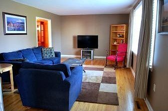 Expansive living room has hardwoods & bay window