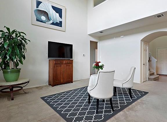 The large open living/family room boasts high ceilings and enjoys panoramic greenbelt views from the many windows.