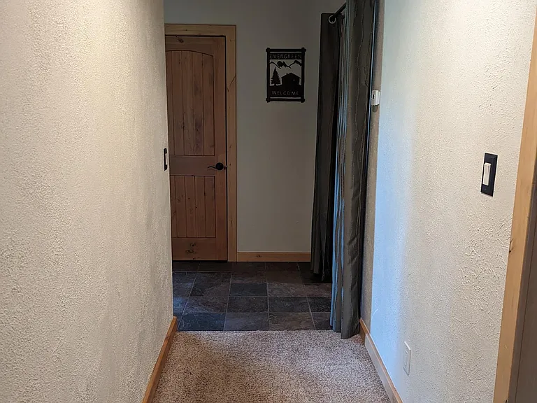 Hallway on ground level, connecting the 3rd bedroom suite and 4th bedroom/ bonus space to foyer and laundry room.