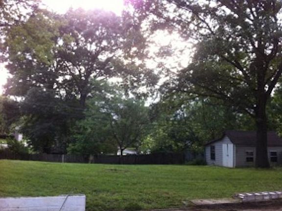 Large fenced yard with storage shed.
