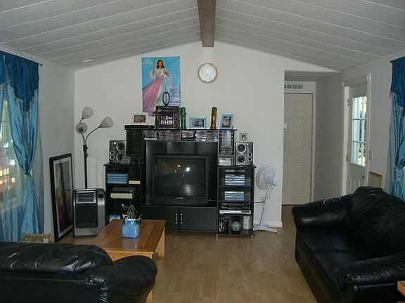 Living room features new Pergo flooring, vaulted ceiling & new vinyl windows.
