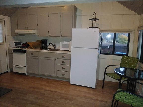 kitchenette with refrigerator, microwave, toaster oven, gas stove, coffee maker, dishes, etc