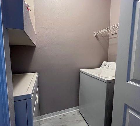 Laundry room with "full size brand new" washer and dryer.