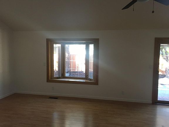 Open concept living room and kitchen with window seat to backyard