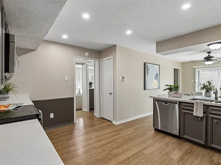 Kitchen featuring wood-finish flooring, recessed lighting, and a kitchen peninsula with quartz countertops and an undermount sink