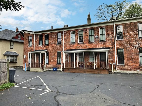 Back of condo units with fenced in parking lot shared with two houses on Rose st