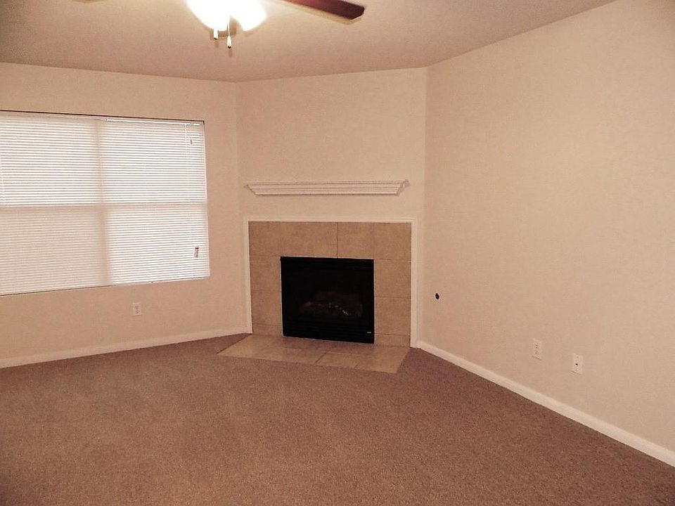 Corner gas log fireplace and new carpeting in living area.