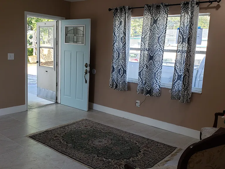 View of Living Area and Front Entry Door. View from Hallway with Front Door Open.