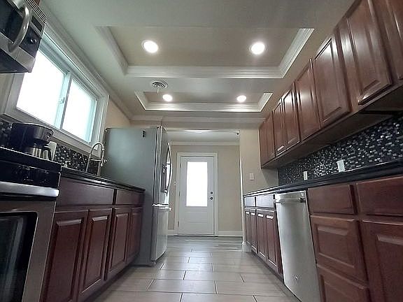 Porcelain tile floor. Porcelain is some of the strongest tile and can last for decades. 6 recessed lights with a dimmer switch at each end of the kitchen provide ample lighting but can also be dimmed to your preference. The ceiling features three separate ceiling trays which makes this kitchen look really distinguished