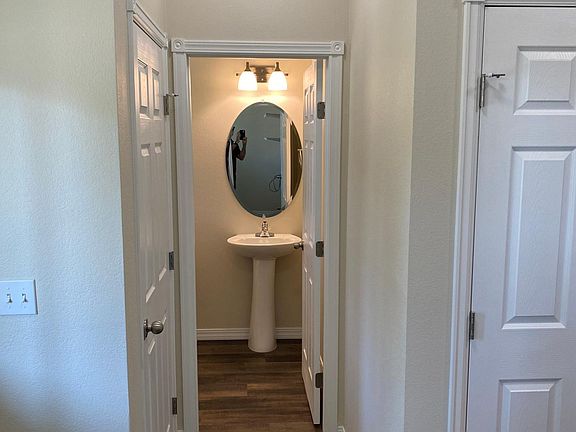 Main level half bath and coat closet on the left, basement entrance door on right
