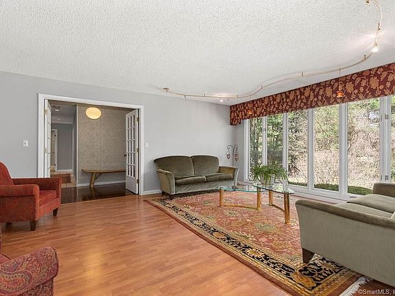 Living room with wall of windows for light all day long. Sun setter motorized solar shades are installed for light control in windows along the front of the home and the master bedroom.
