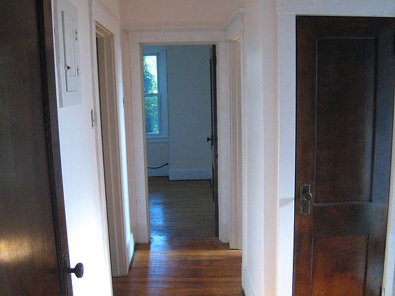 Hallway from dining room to bedrooms and bathroom. Linen closet is the door on the right. Bathroom door is on the far right, out of view. Bedroom 2 is straight back through the open door.
