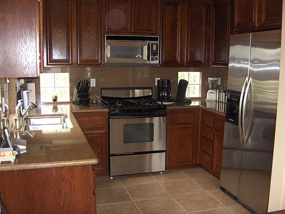 Kitchen with granite, dark wood and stainless steel
