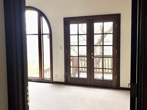 Bedroom w/ French doors leading to wrap around deck.