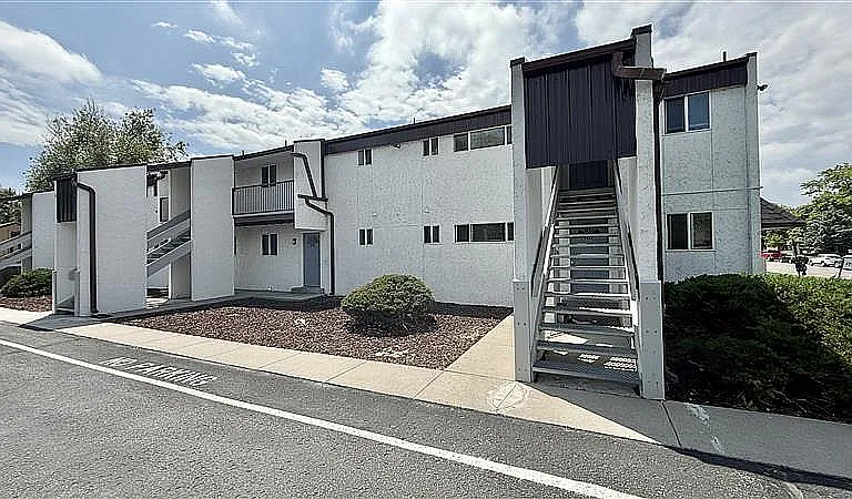 Charming two-story apartment building with modern exterior, featuring unique architectural design and private entrance.