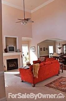 Two Story Living Room and Dning Room : Open two-story living room with ceiling fan and fireplace